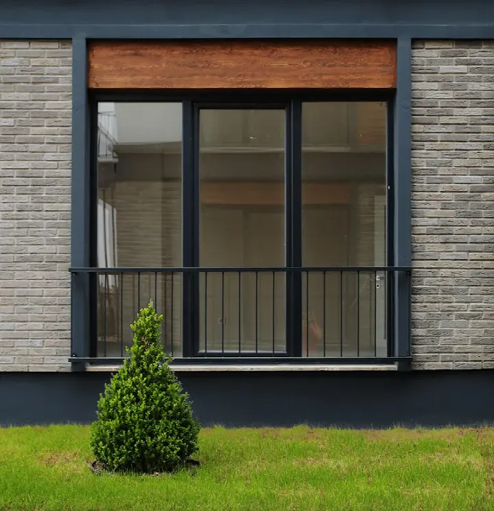 Gri tuğla kaplamalı modern cephe ve siyah doğramalı pencere