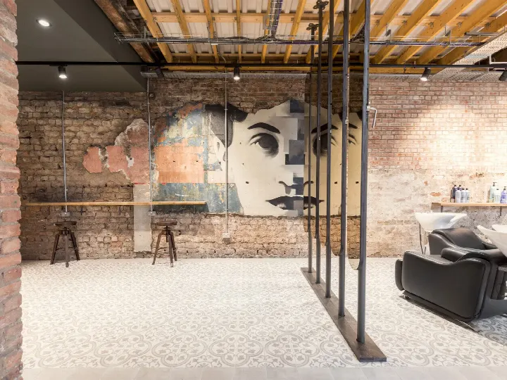 Kuaför salonunda eskitilmiş tuğla duvar ve sanat panosu