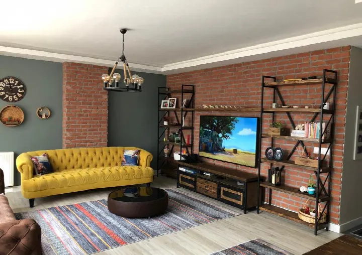 Salonda TV ünitesi arkasında kültür tuğlası duvar