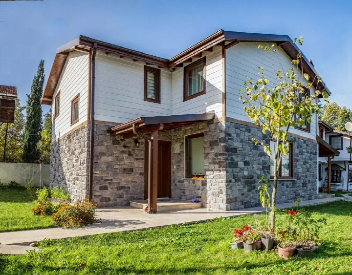 Villa girişinde taş kaplama uygulaması ve verandalı cephe