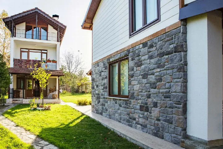 Villa köşesinde gri taş duvar kaplama ve bahçe, yakın açı